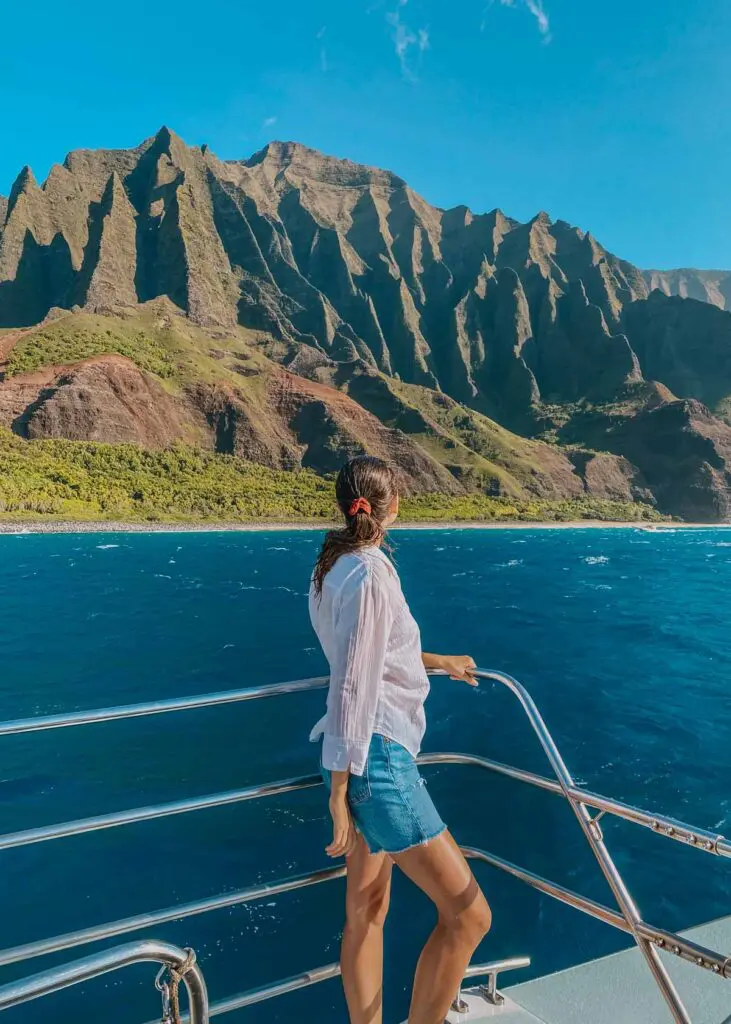Woman on a boat tour along the Napali Coast, one of the top places to visit in Kauai