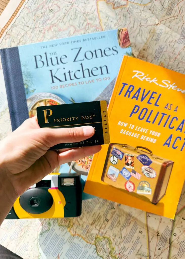 Travel gift ideas, including an airport lounge membership card, a travel book, a travel cookbook, and disposable film camera for travel.