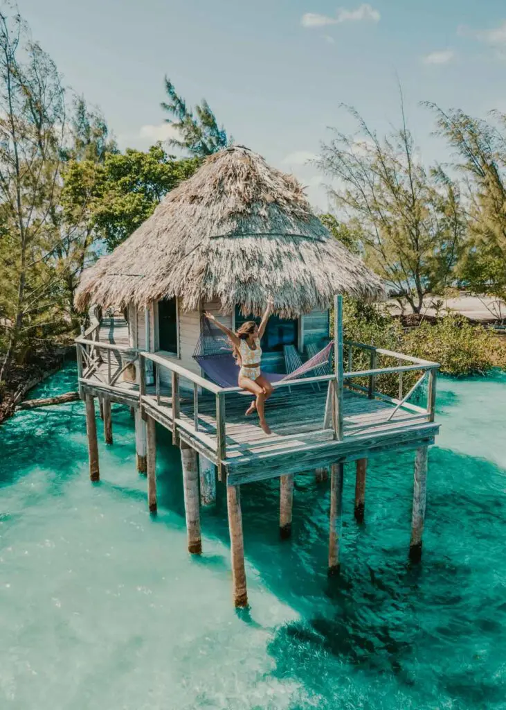 Girl holding hands in the air on an overwater bungalow in Belize