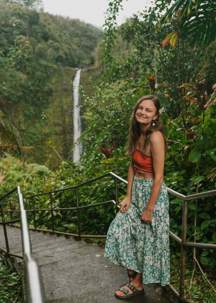 Woman standing in front of waterfall in Hawaii