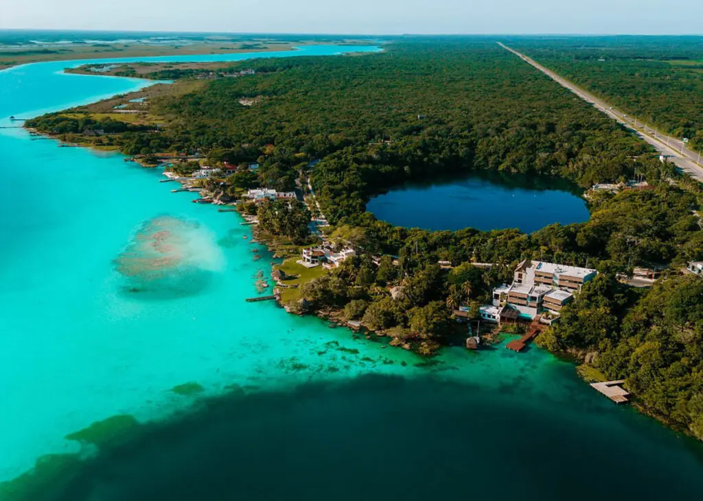 Drone view of Hotel Amainah Bacalar, neslted between Cenote Azul and Cenote Cocalitos in Bacalar.