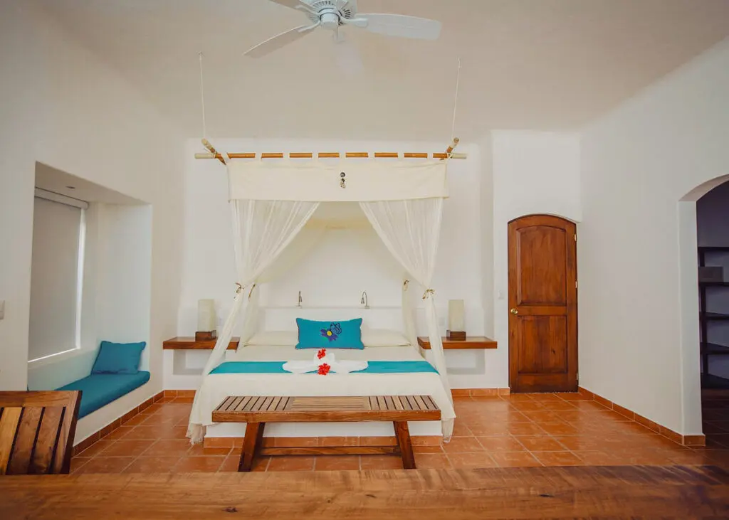 Hotel Rancho Encantado cabin bedroom with wooden accents, blue and white designs.