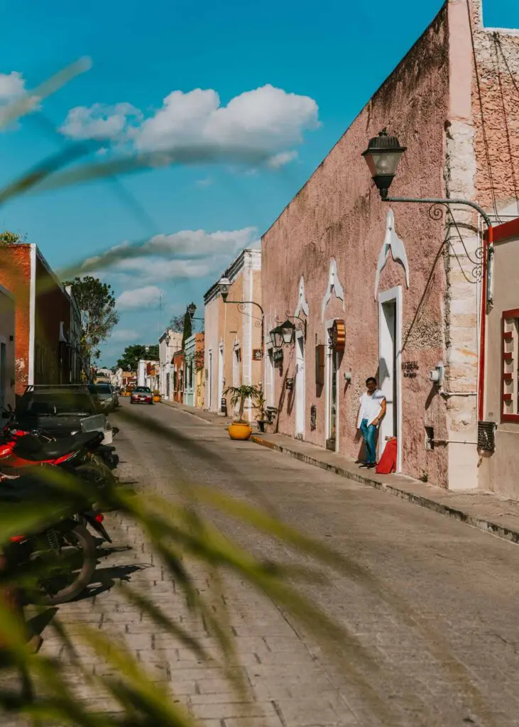 A street in a quaint town with colorful buildings and vintage street lamps in Valladolid, Mexico, one of the best places to visit during a Cancun vacation.