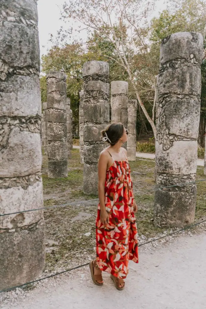 Woman stands in front of some of the thousand columns at the Temple of the Warriors at Mexico's Chichén Itzá park