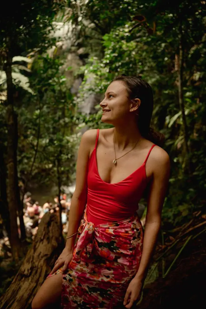 Woman standing in front of El Yunque Waterfall, one of the best things to see in Rio Grande Puerto Rico. 