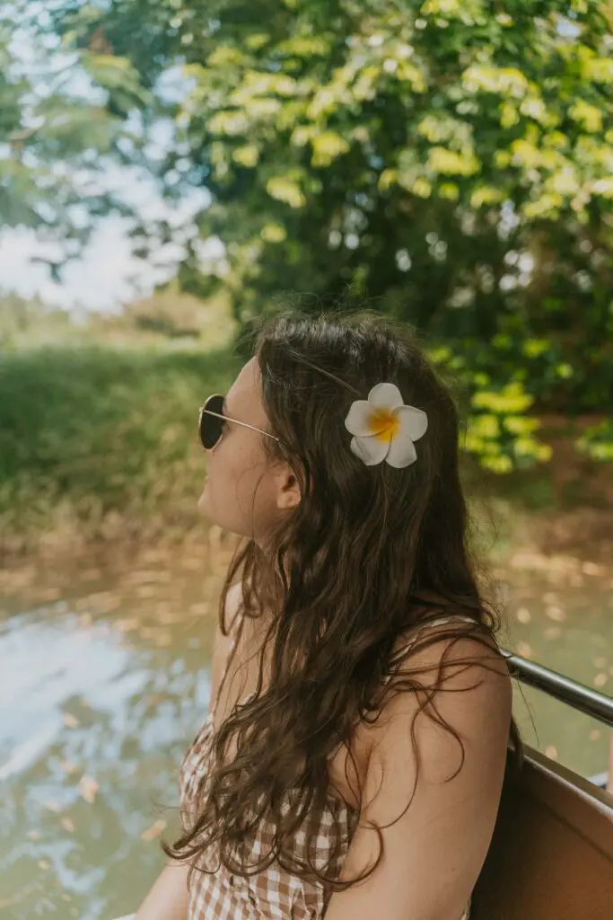 Woman with flower in her hair  cruising down Rio Espiritu Santo, one of the best things to do in Rio Grande, Puerto Rico