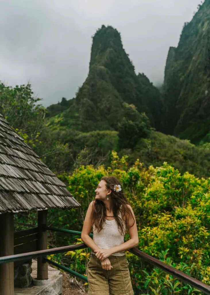 Woman standing in front of the Iao Valley Needle, one of the must see spots on this Maui itinerary