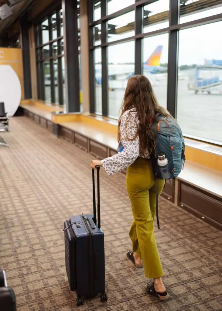 Traveling at the airport with a backpack, water bottle, and luggage