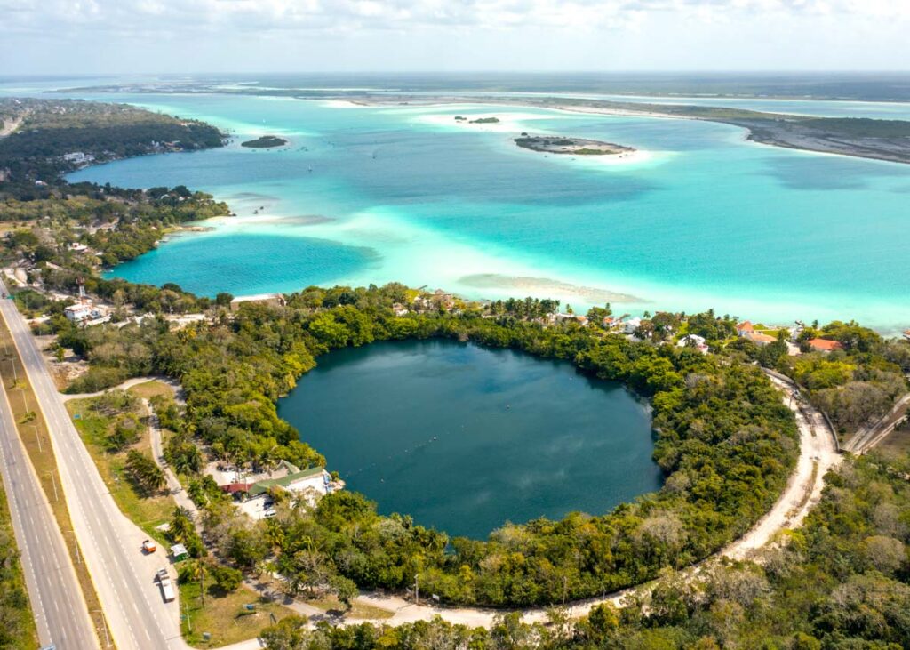 Drone view of three Bacalar cenotes beside the Bacalar lagoon of seven colors.