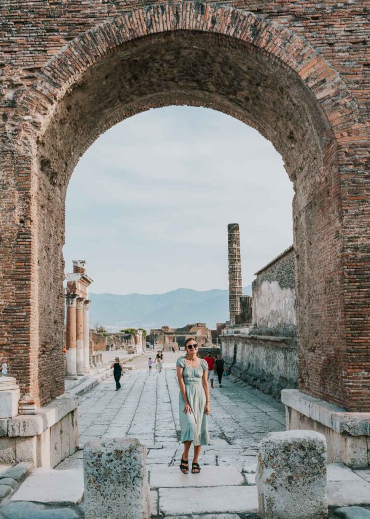 Me standing beneath an arch while exploring Pompeii during my southern Italy vacation