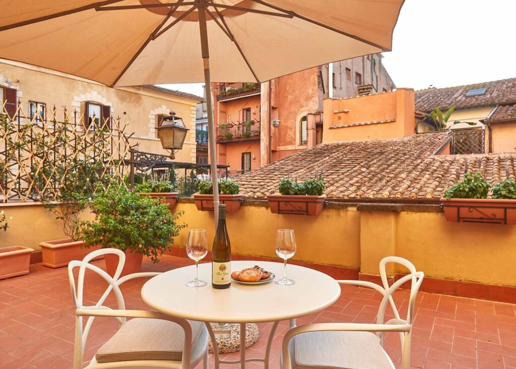 Wine and pastries set out on a table on a rooftop patio at Ripagrande a Trastevere in Trastevere, Italy