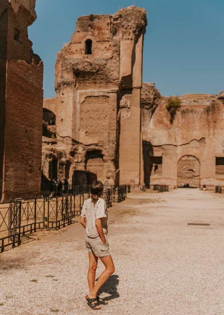 Woman gazes up at the walls of the Baths of Caracalla, one of the highlights of this Rome itinerary 